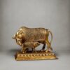 Handcrafted brass Kamdhenu cow and calf statue with intricate carvings on an engraved pedestal