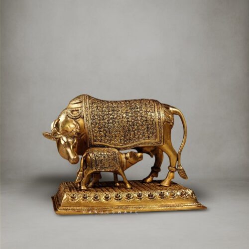 Handcrafted brass Kamdhenu cow and calf statue with intricate carvings on an engraved pedestal