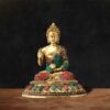 Handcrafted brass Buddha statue with semi-precious stone inlay work in blessing posture on ornate pedestal