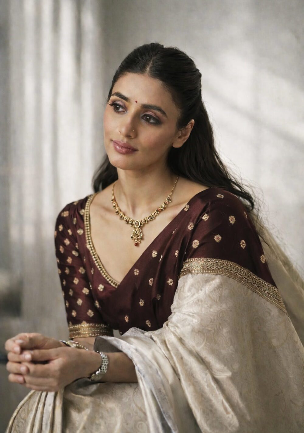 Antique gold temple choker necklace set with multicolor stones and matching earrings on silk background