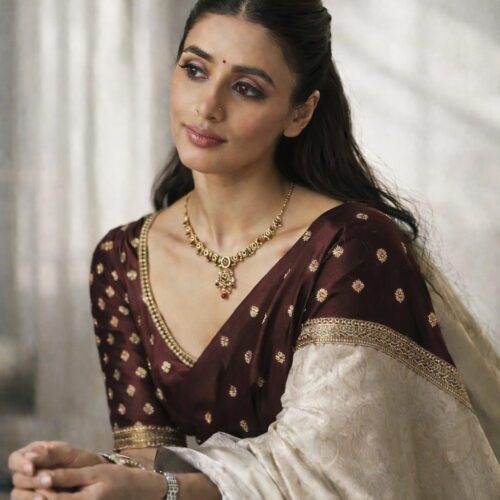 Antique gold temple choker necklace set with multicolor stones and matching earrings on silk background