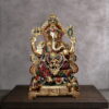 Handcrafted brass Lord Ganesha statue with colorful Meenakari enamel work, antique gold finish, four-armed blessing pose, sacred Om base, and intricate crown detailing. Ideal for Hindu home temple worship and spiritual decor.