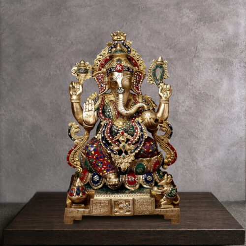 Handcrafted brass Lord Ganesha statue with colorful Meenakari enamel work, antique gold finish, four-armed blessing pose, sacred Om base, and intricate crown detailing. Ideal for Hindu home temple worship and spiritual decor.