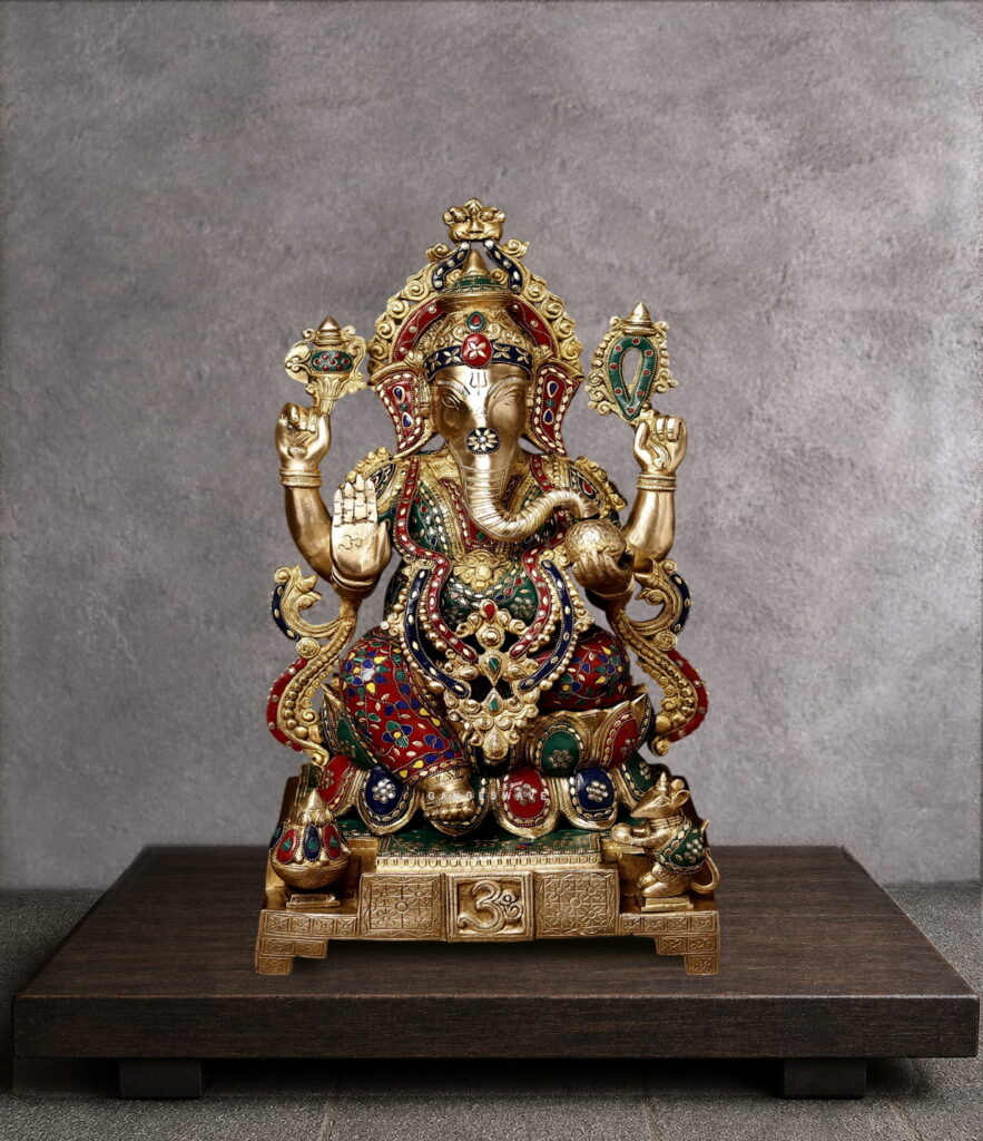 Handcrafted brass Lord Ganesha statue with colorful Meenakari enamel work, antique gold finish, four-armed blessing pose, sacred Om base, and intricate crown detailing. Ideal for Hindu home temple worship and spiritual decor.