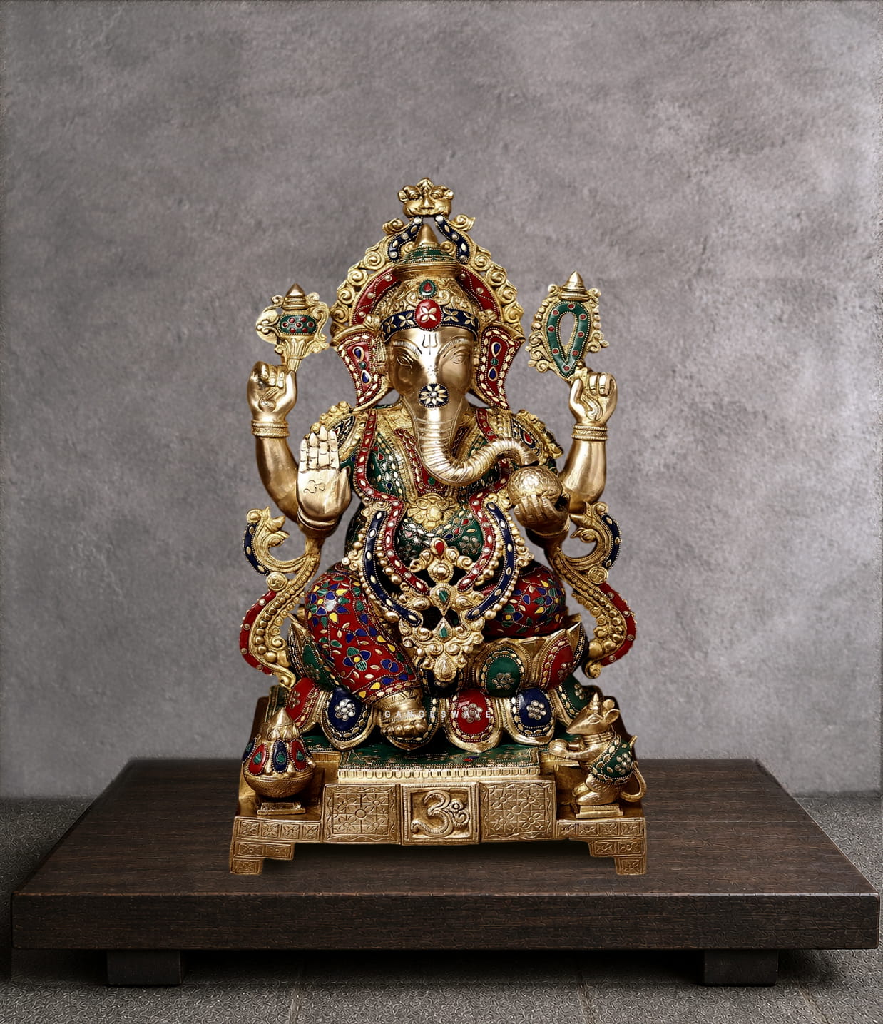 Handcrafted brass Lord Ganesha statue with colorful Meenakari enamel work, antique gold finish, four-armed blessing pose, sacred Om base, and intricate crown detailing. Ideal for Hindu home temple worship and spiritual decor.