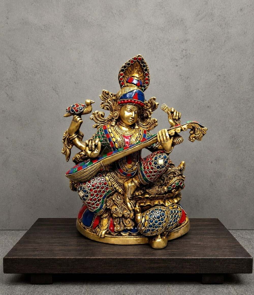 Handcrafted Meenakari brass Goddess Saraswati statue playing Veena with colorful traditional enamel detailing for home temple, study room and luxury décor.
