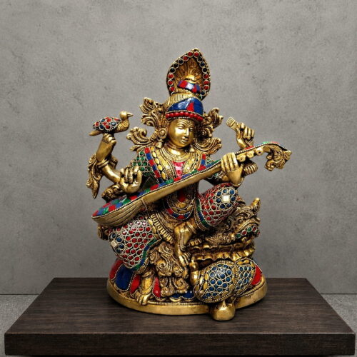 Handcrafted Meenakari brass Goddess Saraswati statue playing Veena with colorful traditional enamel detailing for home temple, study room and luxury décor.