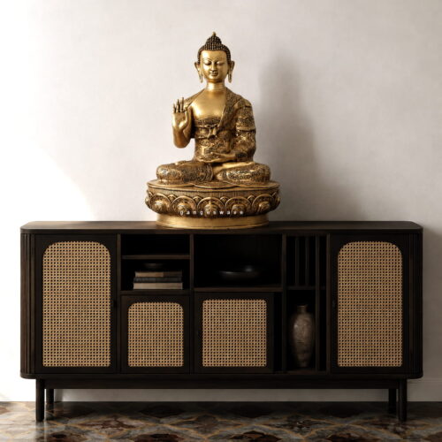 Handcrafted engraved brass Buddha statue with intricate mythological details displayed on a luxury console cabinet
