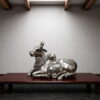 Handcrafted silver finish brass Nandi statue with intricate traditional carvings for Shiva temple, luxury home décor and spiritual interiors.