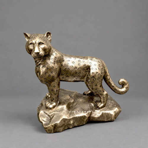 Brass leopard statue with engraved rosette detailing on a sculpted rock base