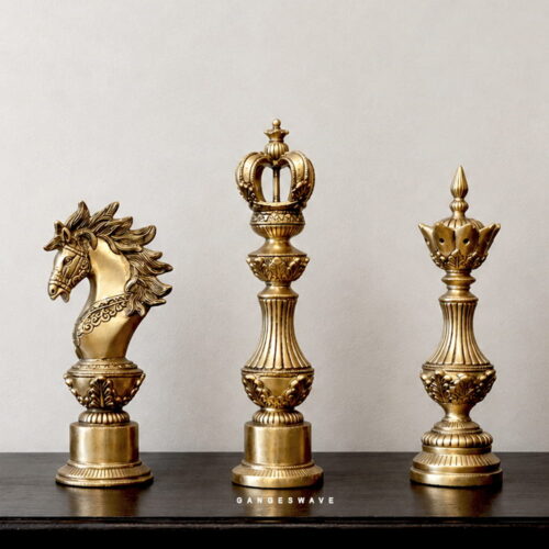 Decorative brass chess pieces with ornate sculptural detailing
