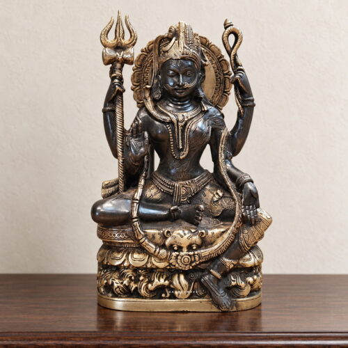 Brass Ardhanarishwar statue depicting Shiva and Parvati with ornate halo, trident and intricately carved pedestal
