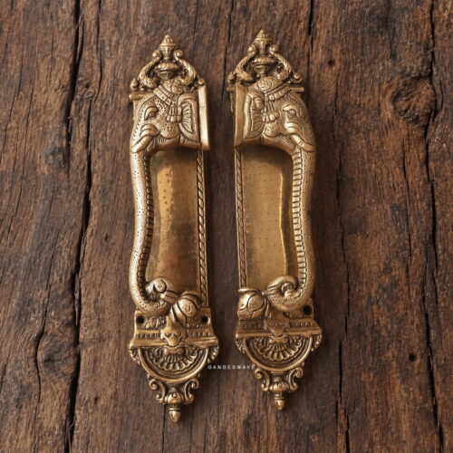 A pair of antique-finish brass elephant door handles with intricate ornamental detailing.
