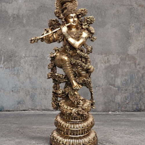 Ornate brass Lord Krishna statue playing the flute with an elaborate crown and decorative pedestal